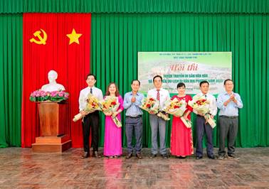 Description: A group of people standing in front of a green curtainDescription automatically generated